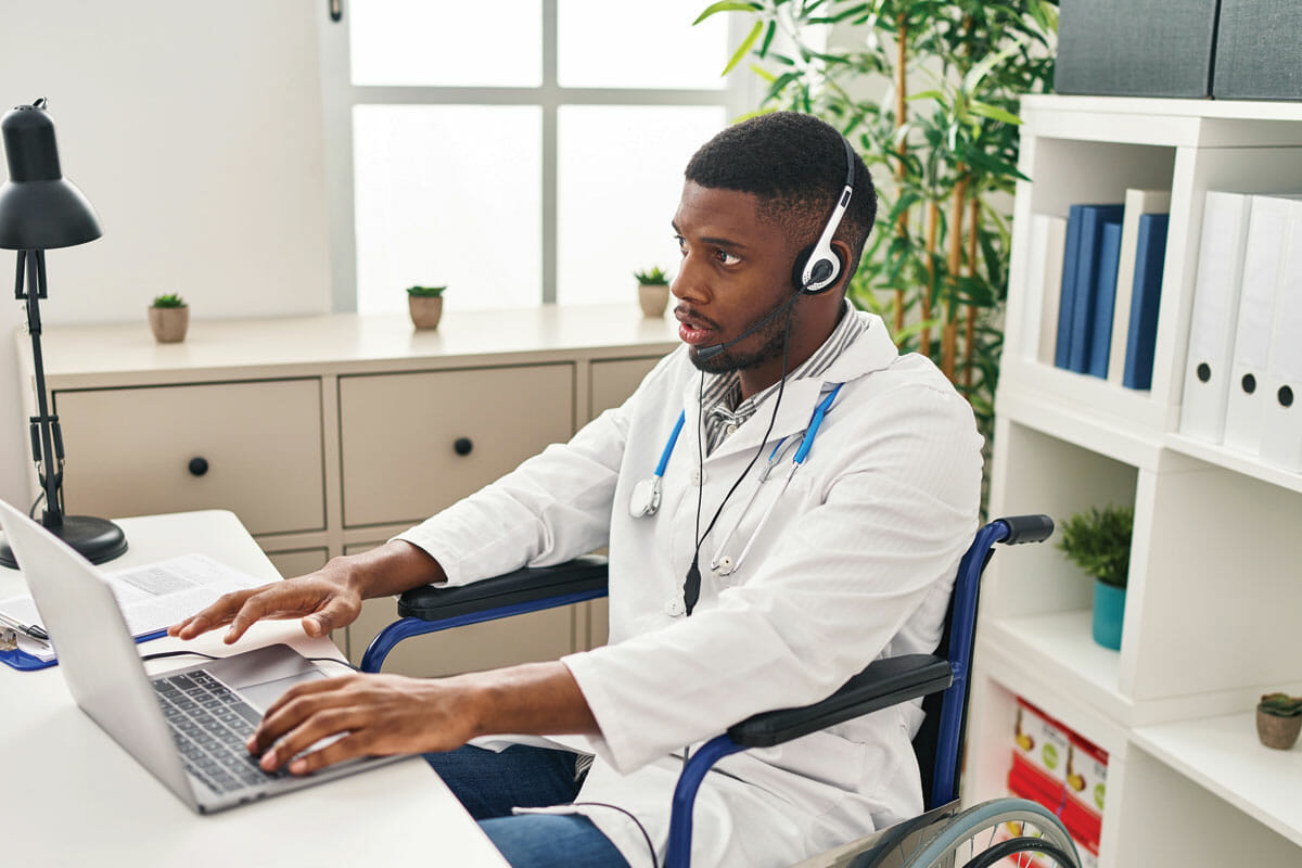 a man in a wheel chair using a laptop computer.