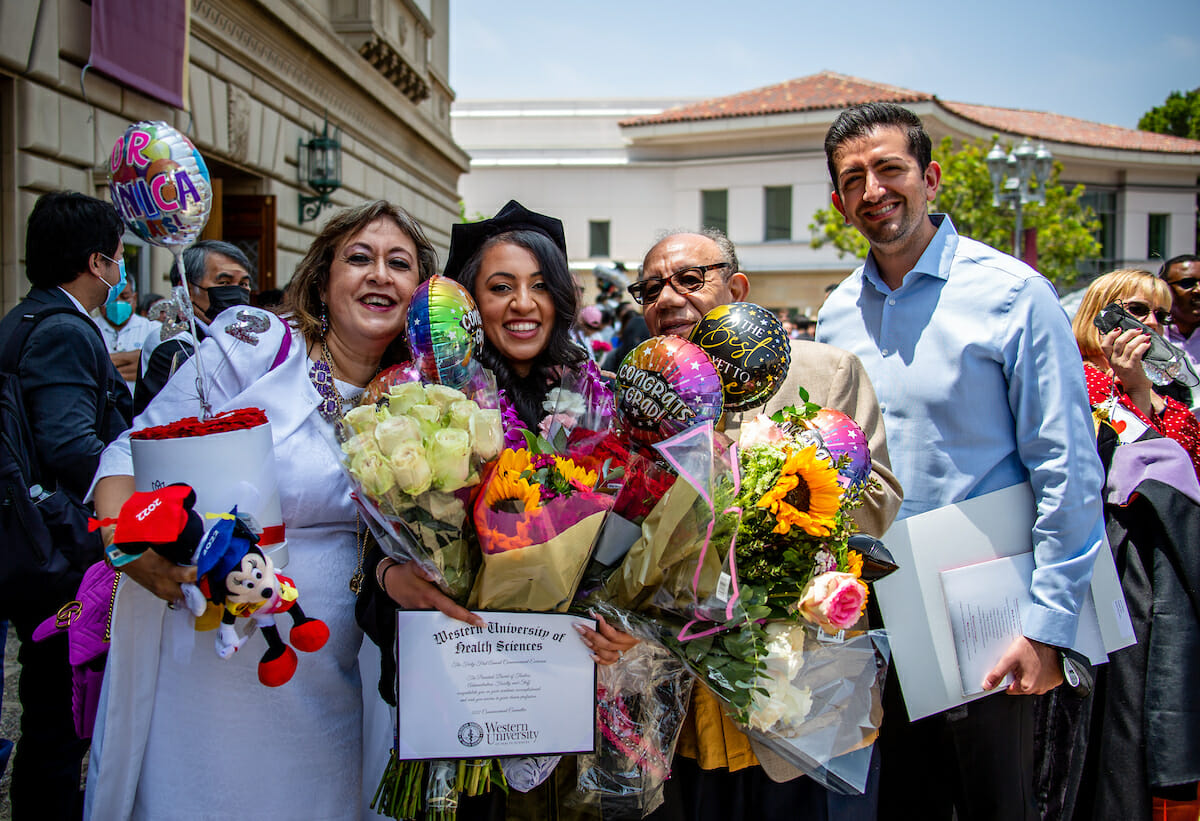A group of people posing for a photo with their diplomas.