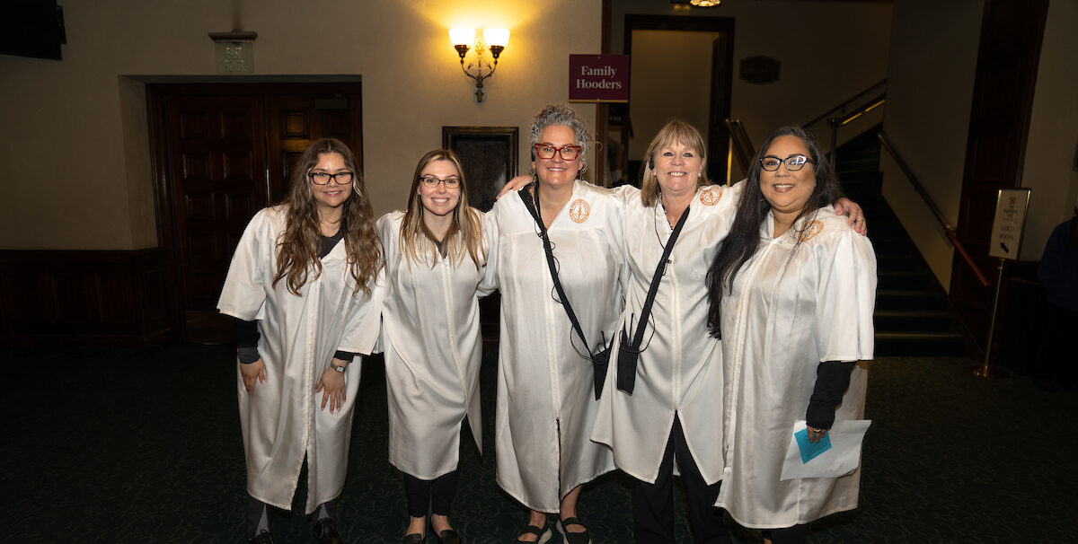 A group of women in white robes posing for a photo.
