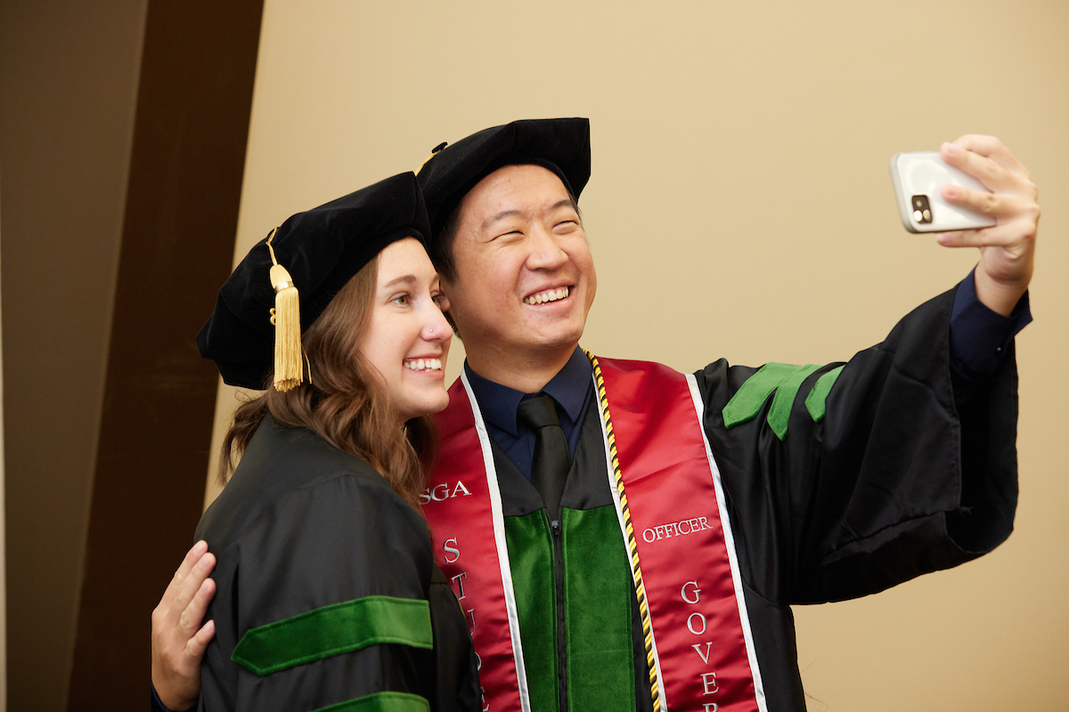 Two graduates taking a selfie.