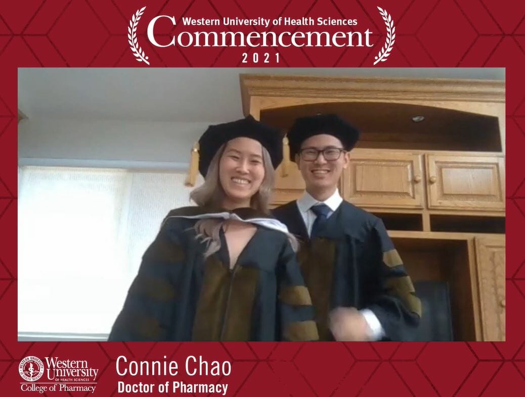Two women in graduation gowns standing next to each other.
