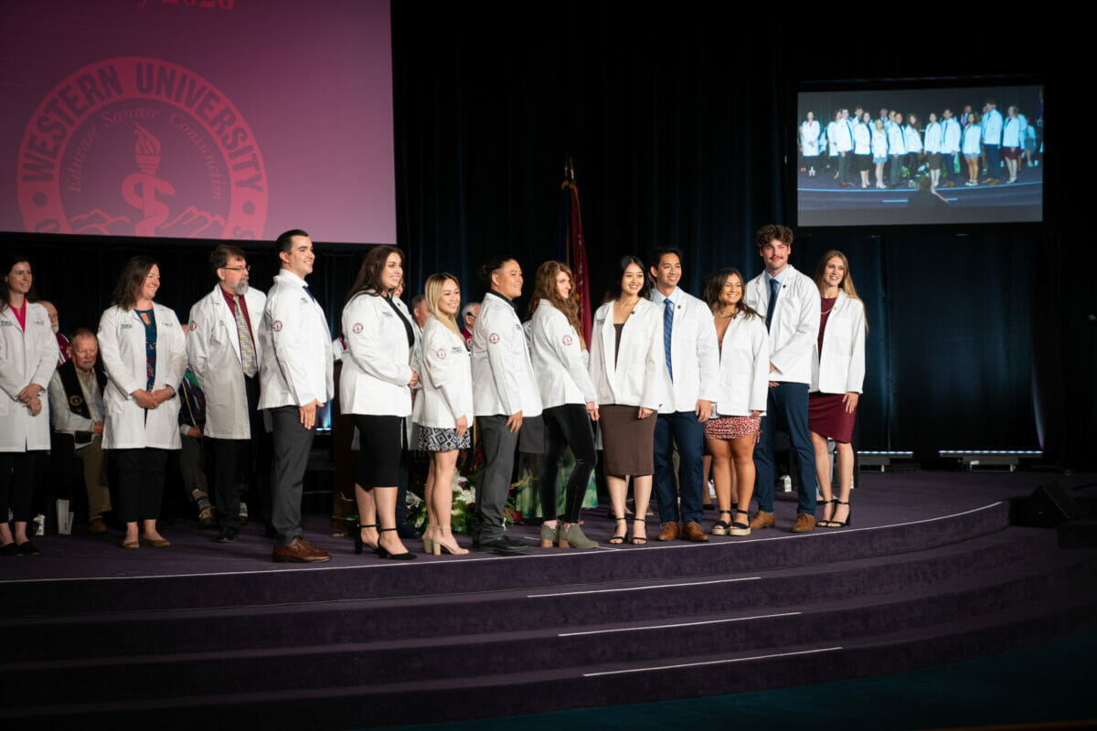 Group, white coats, stage