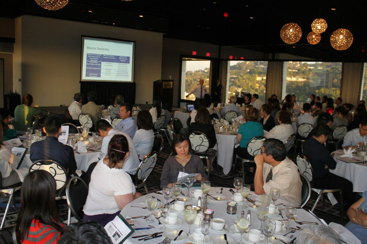 Guests seated at round dining tables during a lecture