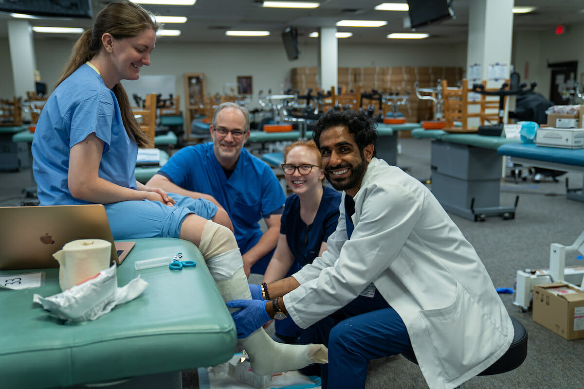 Under the supervision of College of Podiatric Medicine Associate Dean Jonathan Labovitz, DPM, third-year students Devin Phaguda and Bridget Humphrey get hands-on experience with below the knee casting. Resident and alumna Dr. Conley is the