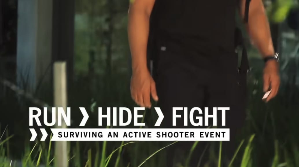 Person walking outdoors with text overlay: “Run > Hide > Fight. Surviving an active shooter event.” Green plants and blurred background visible.
