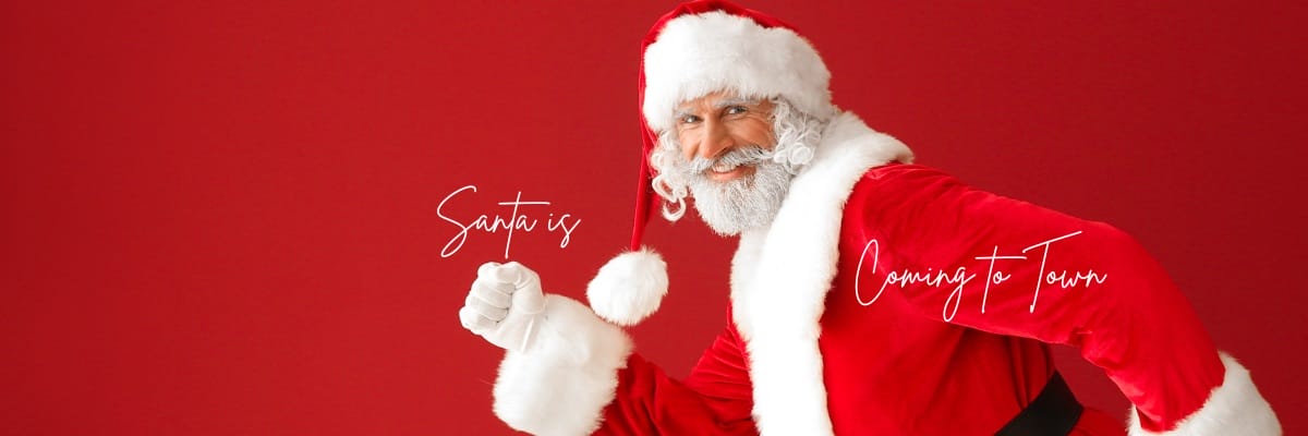 Person in a Santa costume poses against a red background with the text "Santa is Coming to Town.