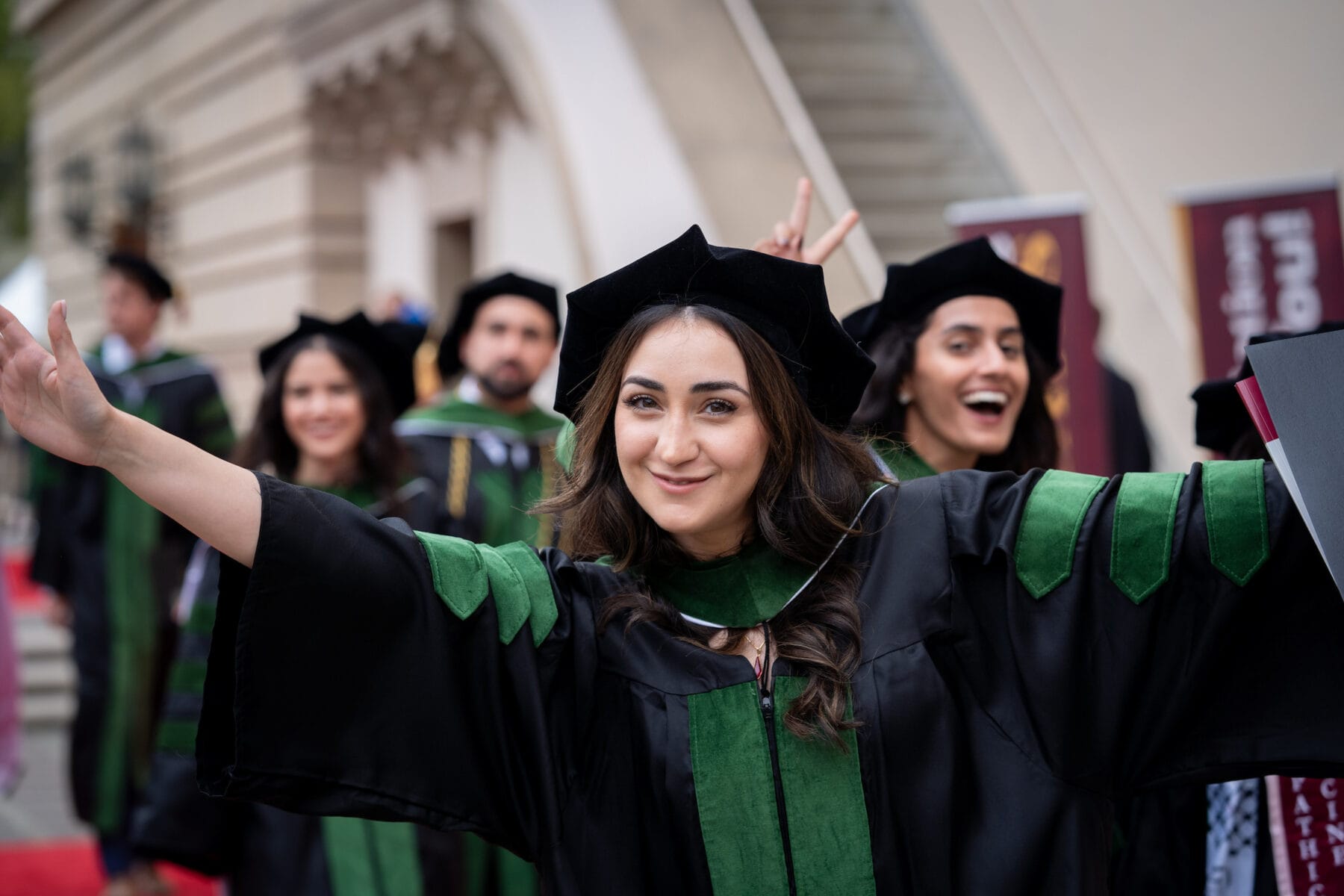 A female wearing a graduation cap and gown smiling
