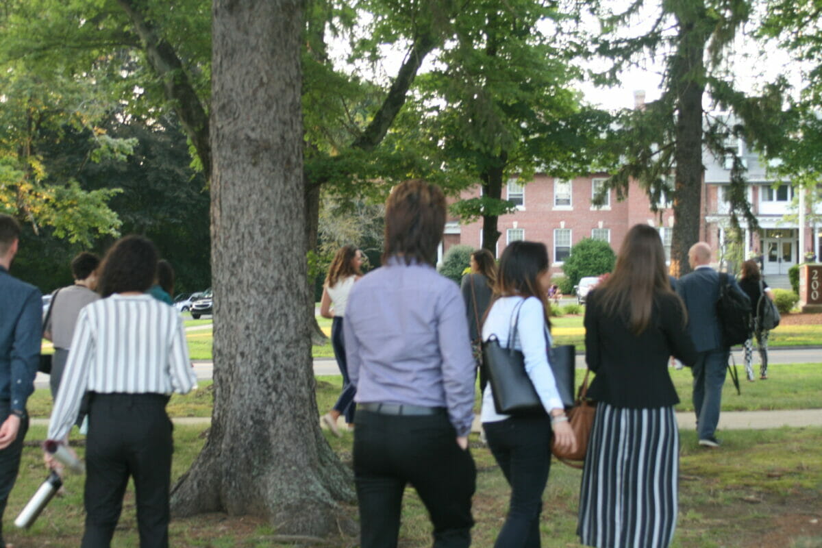 People walking outdoors toward brick building