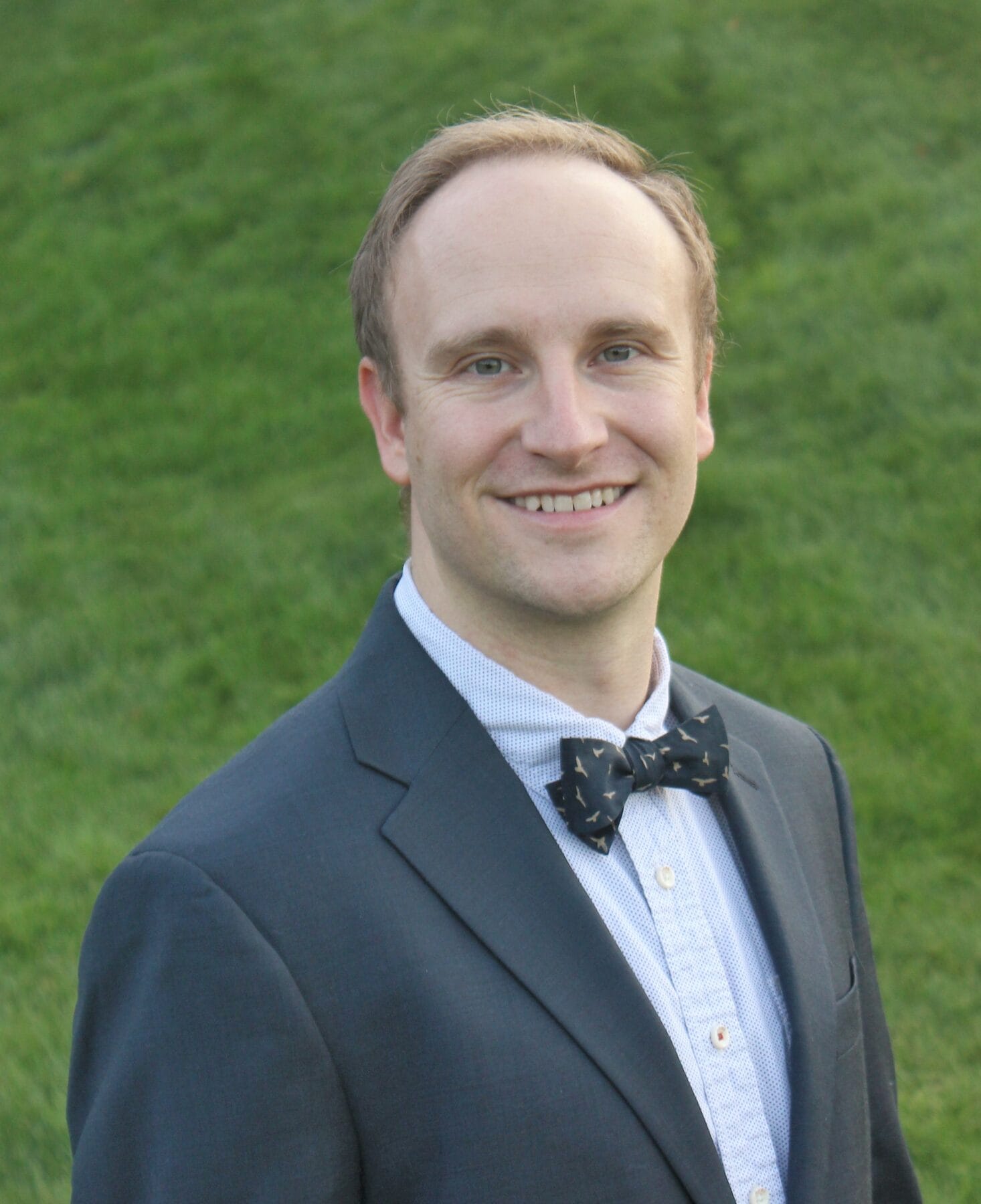 white male dressed in tuxedo smiling